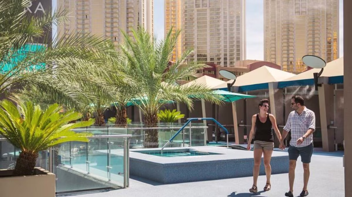 A couple walking together poolside at Elara a Hilton Grand Vacations Club in Las Vegas, Nevada.