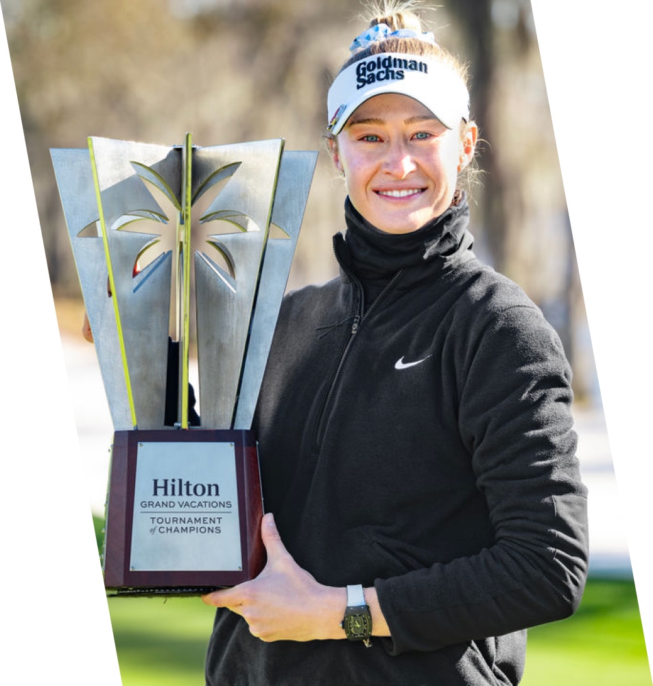 Pro female golfer holding Hilton TOC trophy