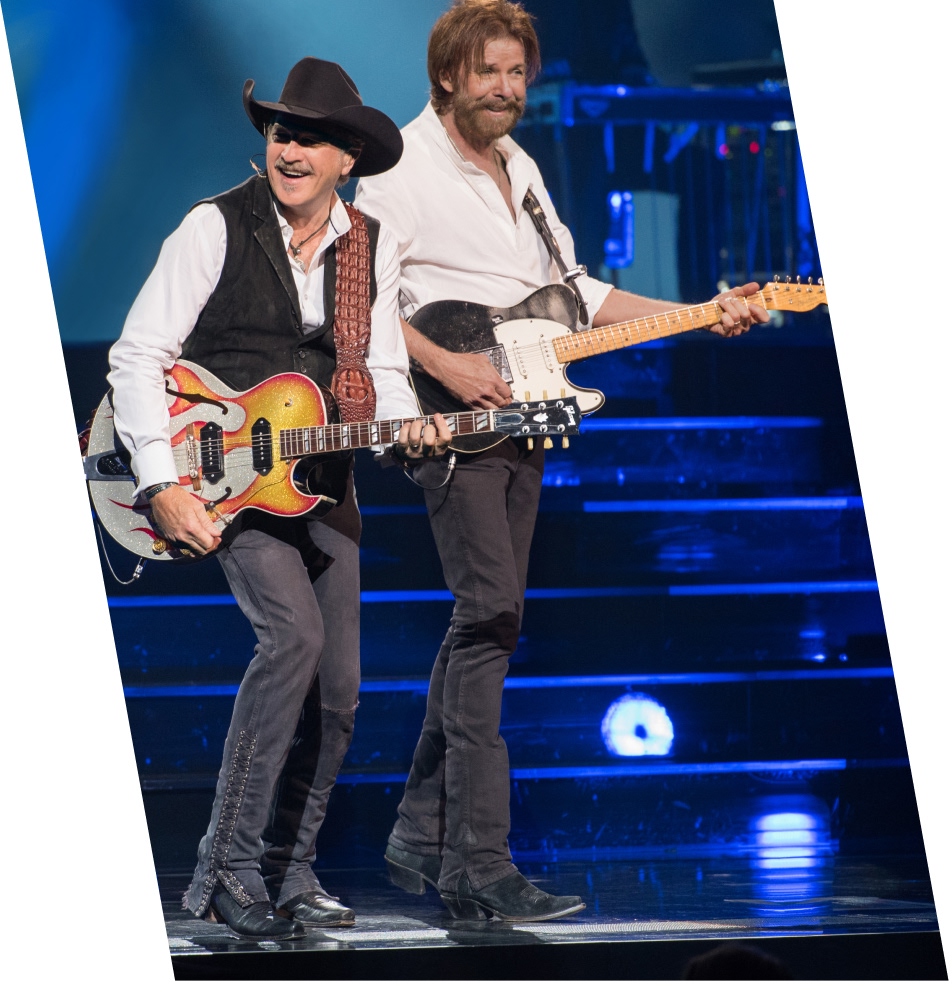 Two artists singing in concert playing guitars