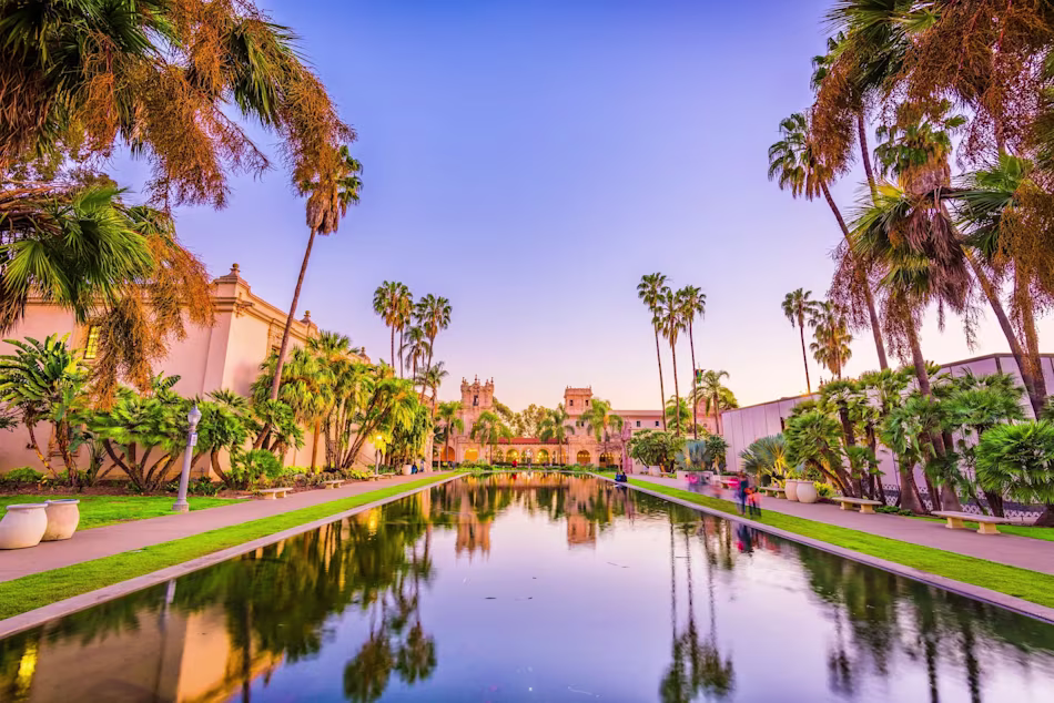 A quite reflecting pool surrounded by palm trees in California.