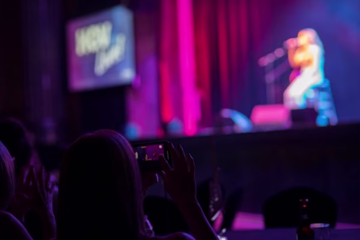 Close up, fan taking picture on phone, Carly Pearce on stage in distance, HGV Live!, Hard Rock Orlando, Florida.