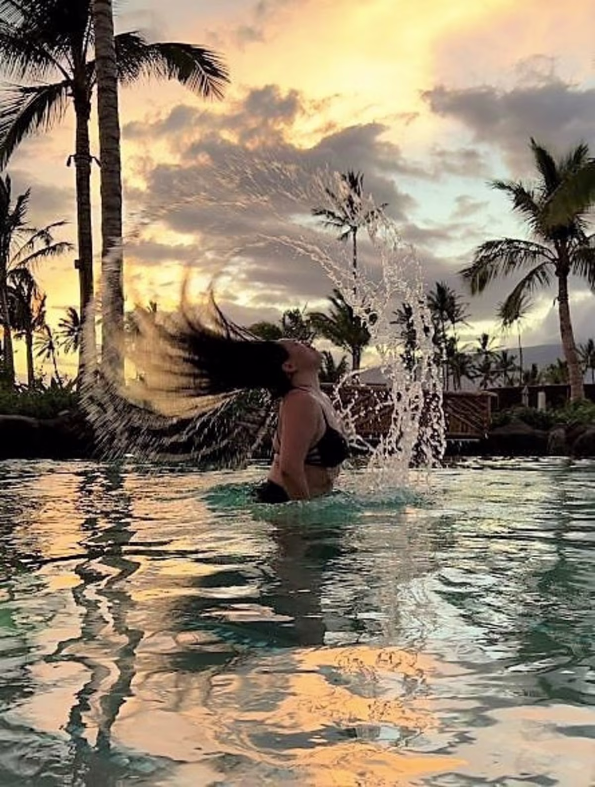 Hilton Grand Vacations Owner frolicking in pool, sunset skies, Maui Bay Villas, a Hilton Grand Vacations Club, Hawaii.