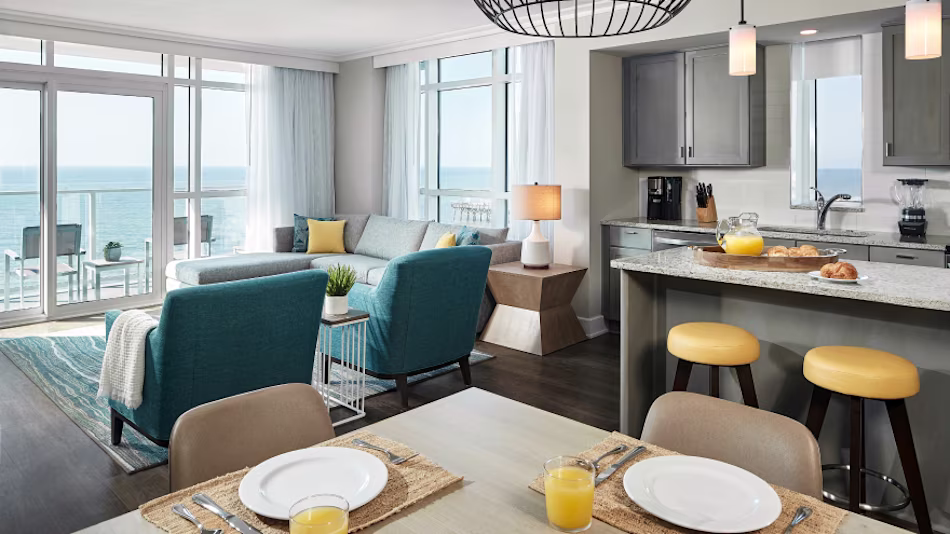 Suite interior, kitchen and dining looking into living area, with a view to the sea.