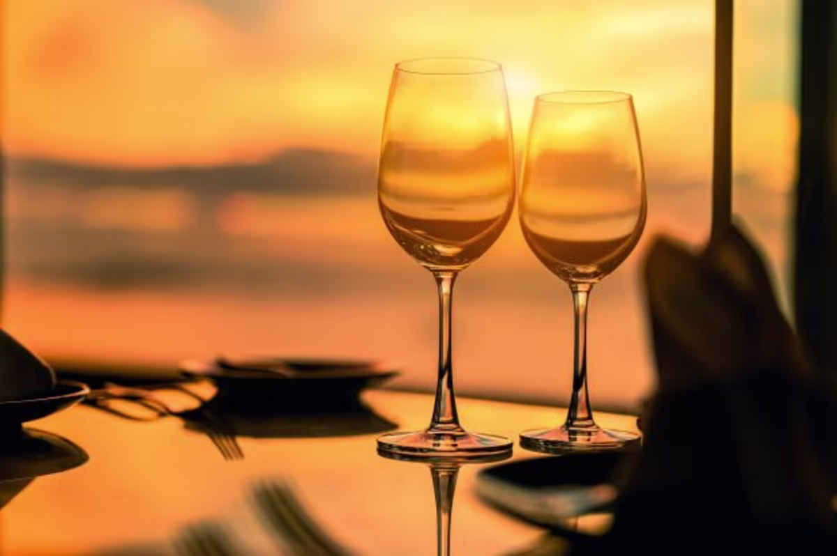 Two wine glasses on a table during a romantic dinner at sunset