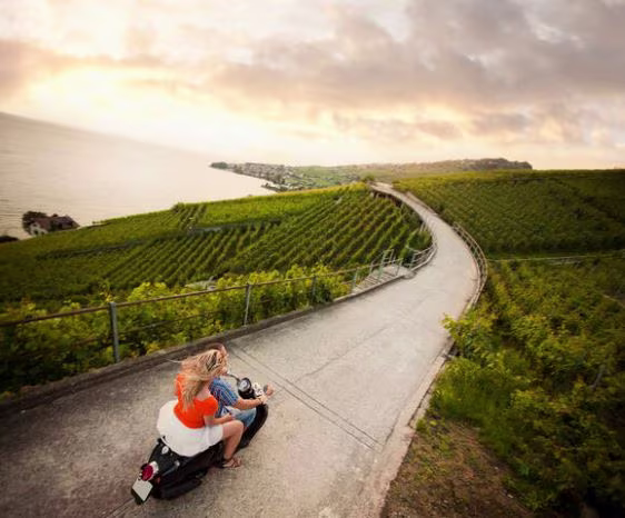 Couple riding on a vesa through the countryside, Tuscany, Italy.