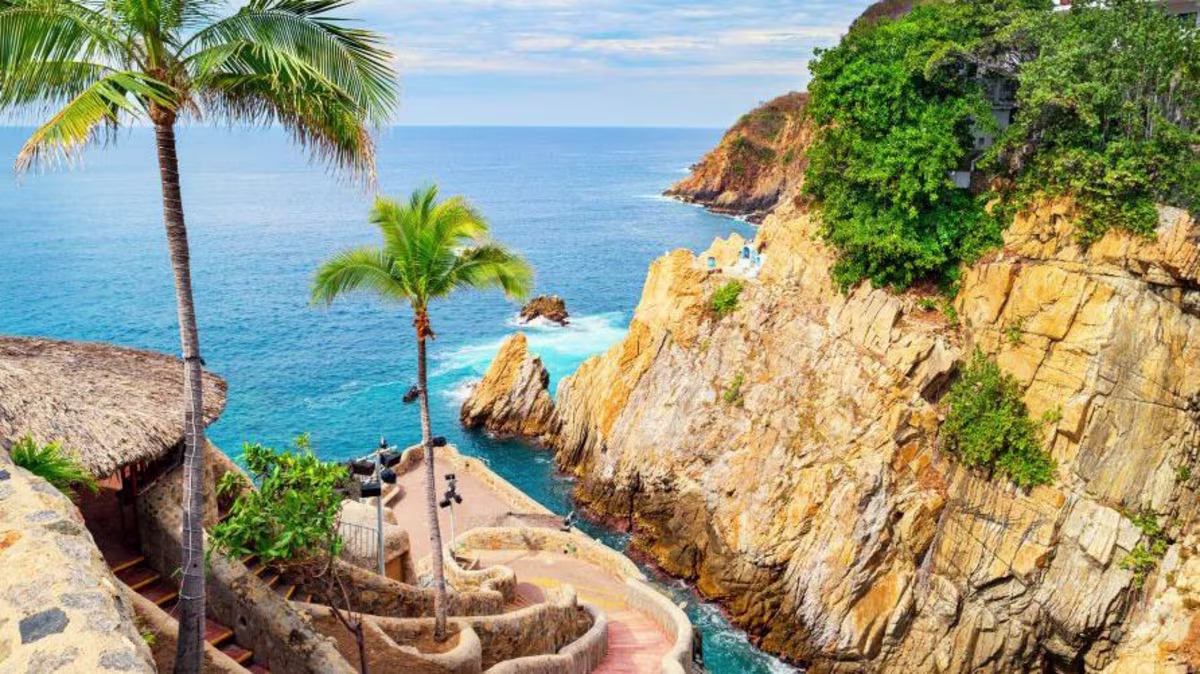 Beautiful cliffside walkway, waterside overlook, honey colored cliffs, blue water, blue skies, Zihuatanejo, Mexico.