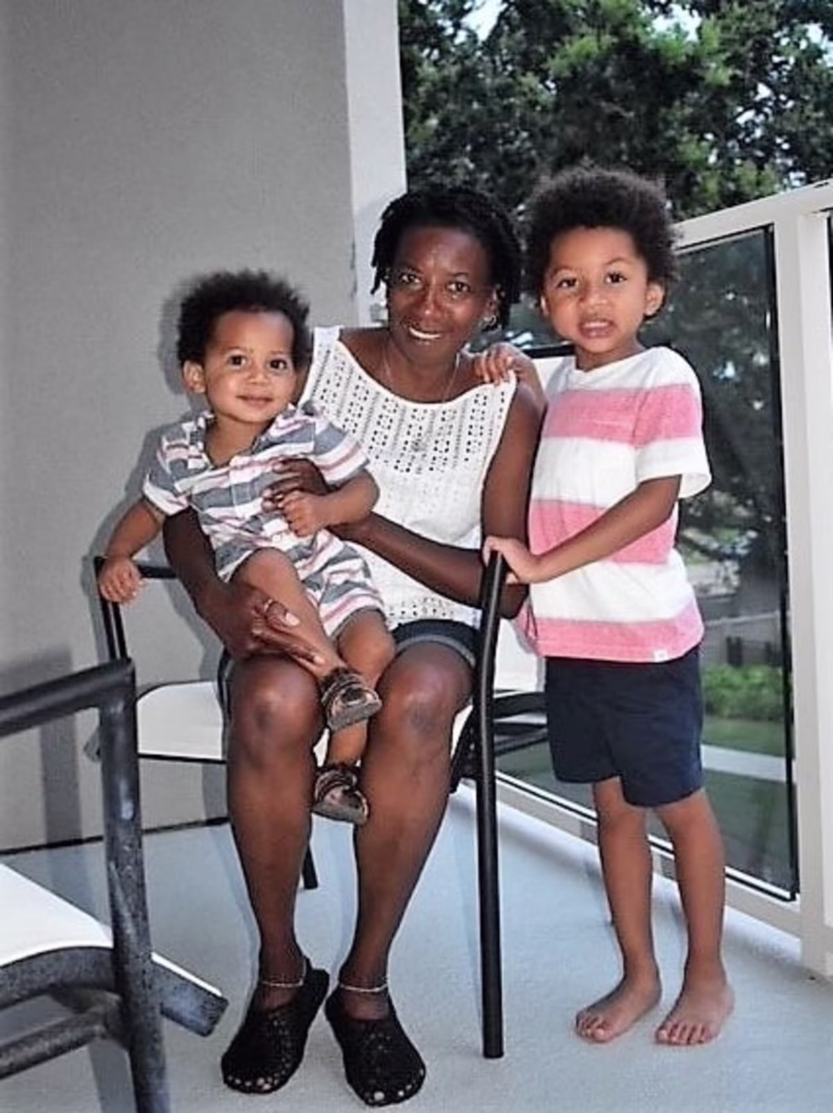 Grandma posing with grandsons on the balcony at Hilton Grand Vacations at SeaWorld in Orlando, Florida.