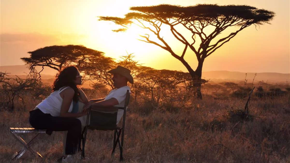 A couple enjoying sunset in the African bush.