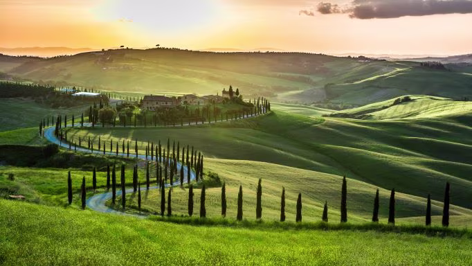 Sunrise over the verdant rolling hills of the Tuscany countryside, Italy.