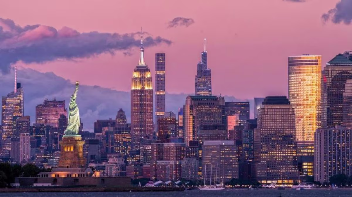 Iconic New York City skyline, Statue of Liberty, New York Bay, purple dusk sky, New York.