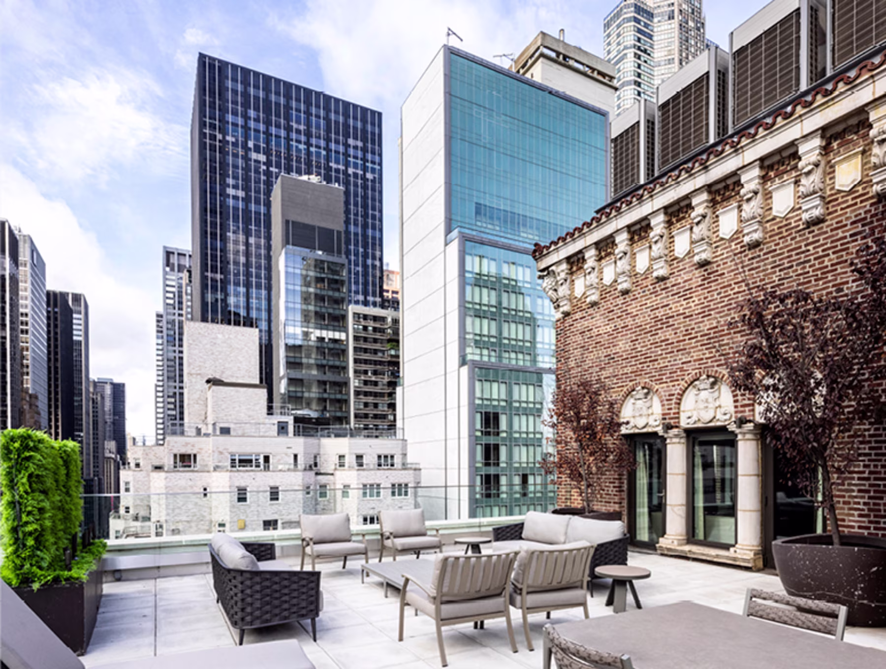 Rooftop patio with modern furniture set against a backdrop of New York City skyscrapers. The scene conveys a blend of urban elegance and relaxation.