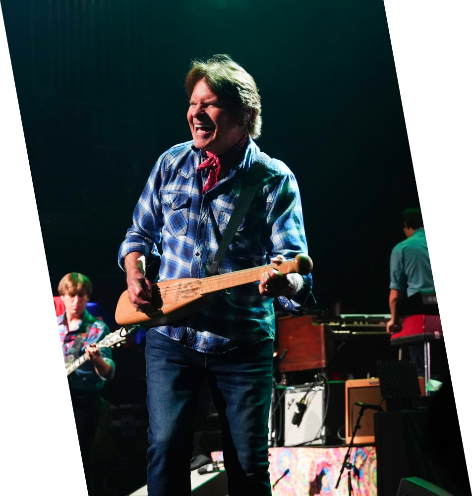 John Fogerty playing a small guitar