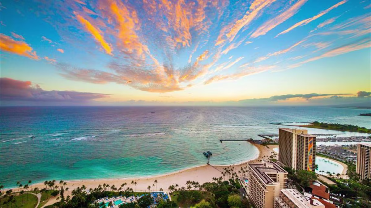 Painted skies overhead Hilton Grand Vacations Hawaii resorts and Hilton Hawaiian Village in Oahu, Hawaii.