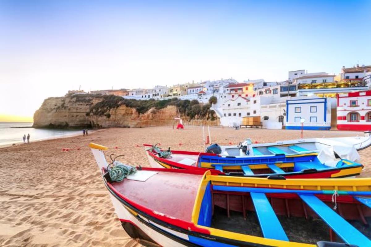 Idyllic beach scene, colorful row boats along shore, Portimão, Portugal.