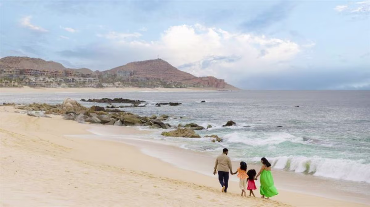 A family walks on the beach near La Pacifica Los Cabos, a Hilton Club in Mexico