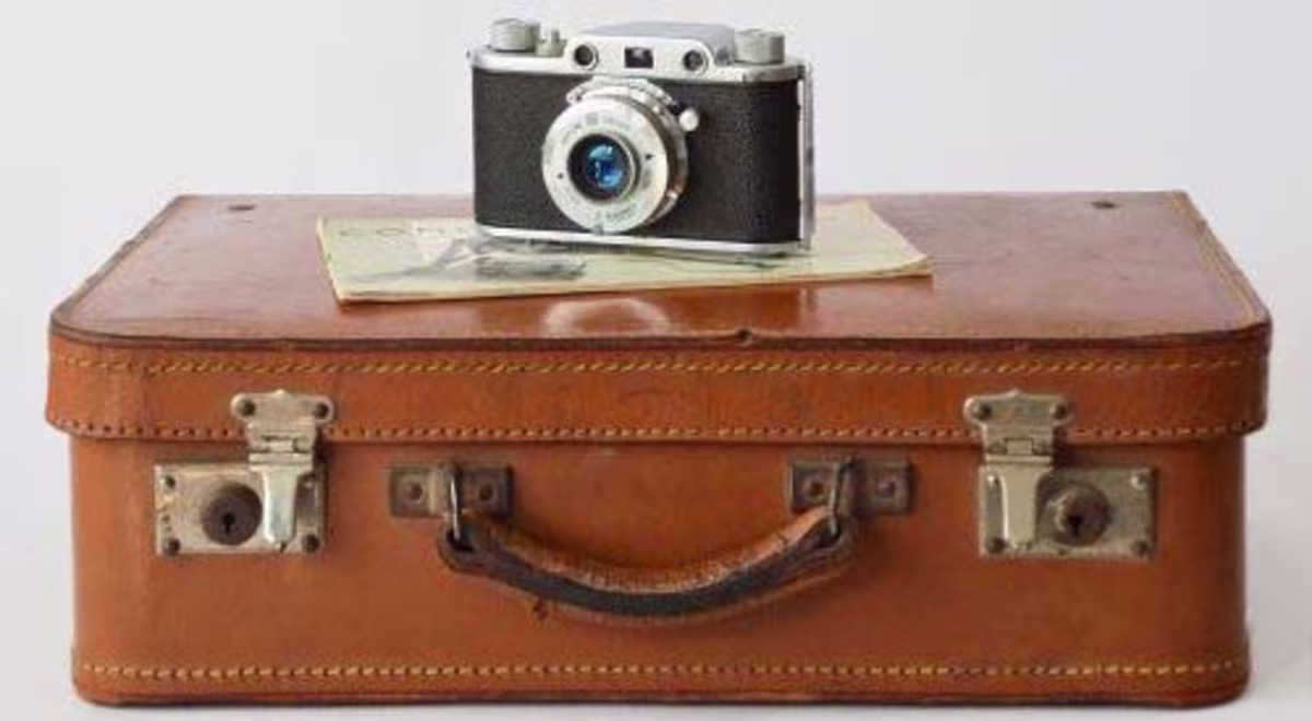 Picture of a classic suitcase with an vintage camera on top.