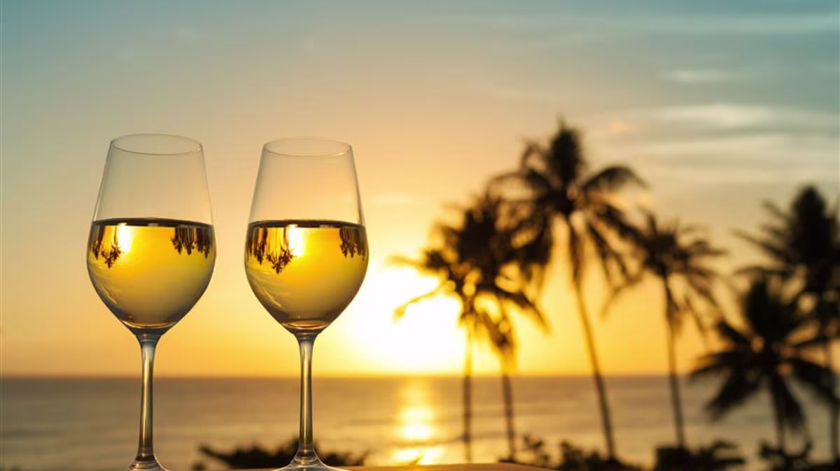 Two glasses of wine with the Hawaiian sunset in the background.
