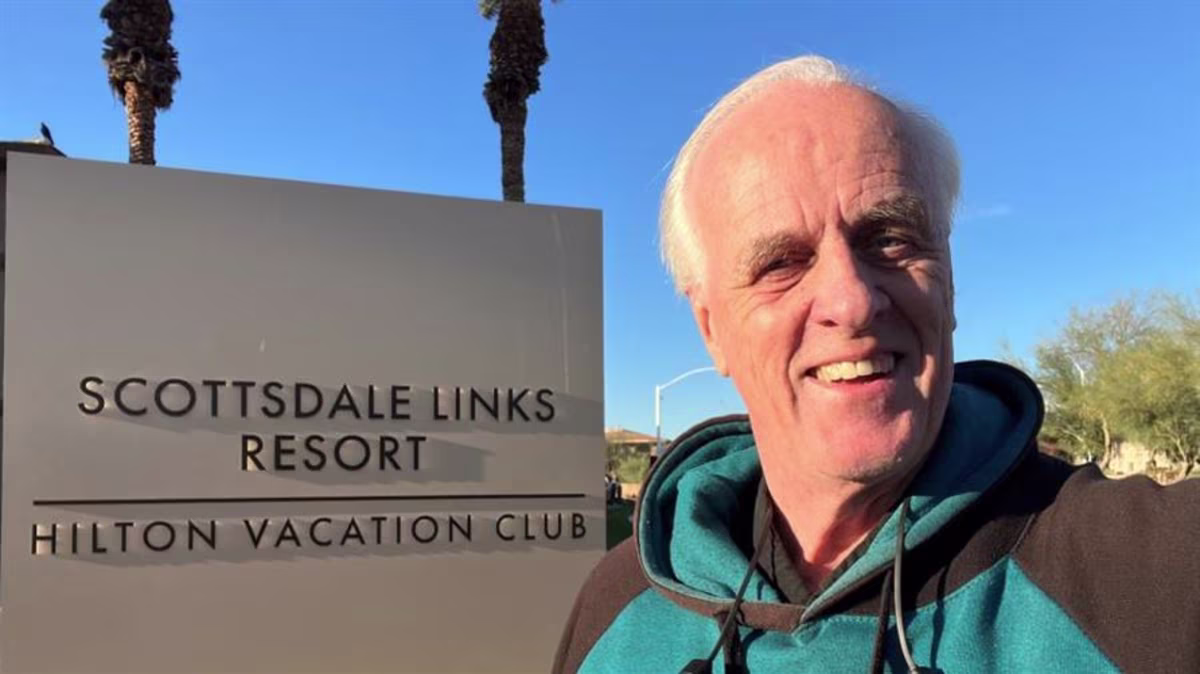 A Hilton Grand Vacations Member next to a sign for Scottsdale Links Resort, a Hilton Vacation Club in Arizona