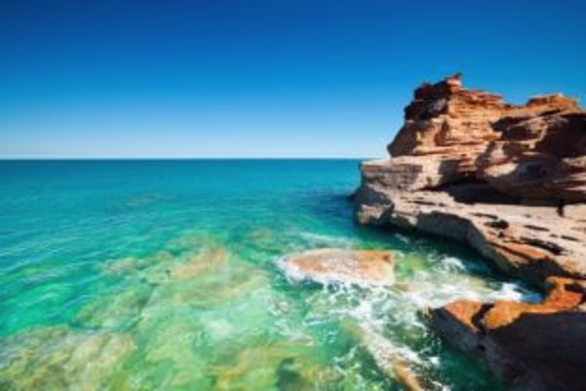 Beautiful coastal image, clear blue waters, blue skies, rocky cliffs.