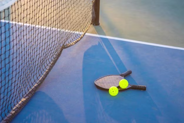 Pickleball paddles on pickleball court.