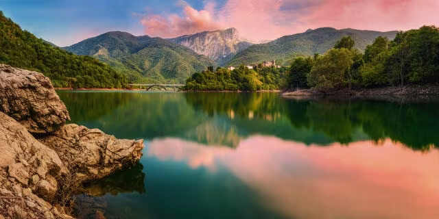 Serene lake vista with mountains and sunset skies, Italy.